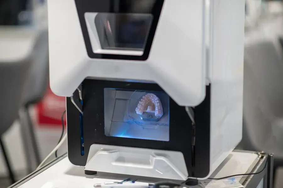 A dental milling unit shaping a crown from a ceramic block
